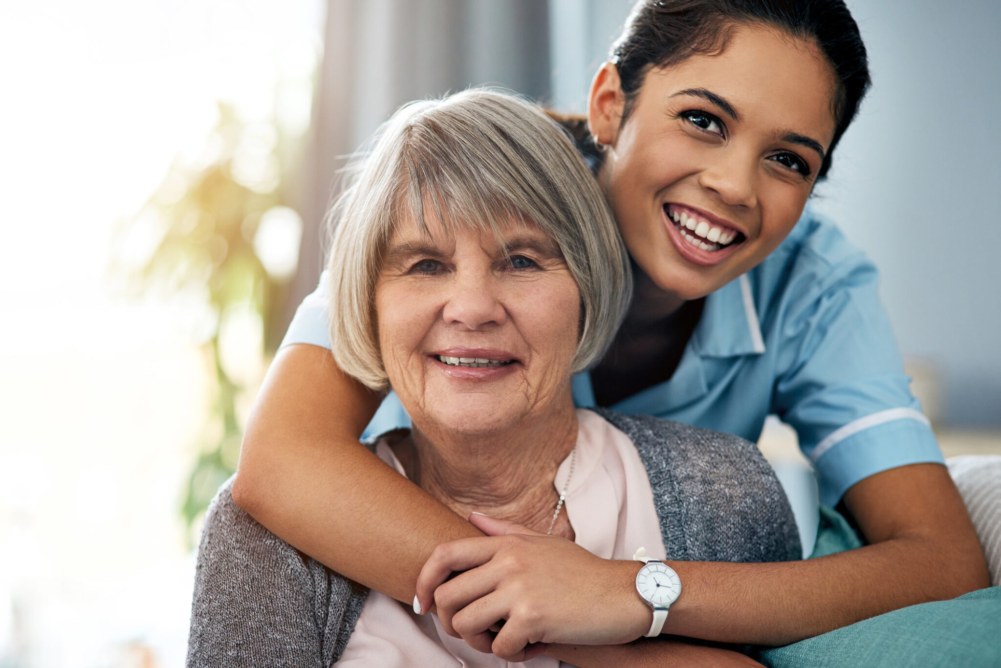 Hoivakodin työntekijä halaa iäkästä naista.