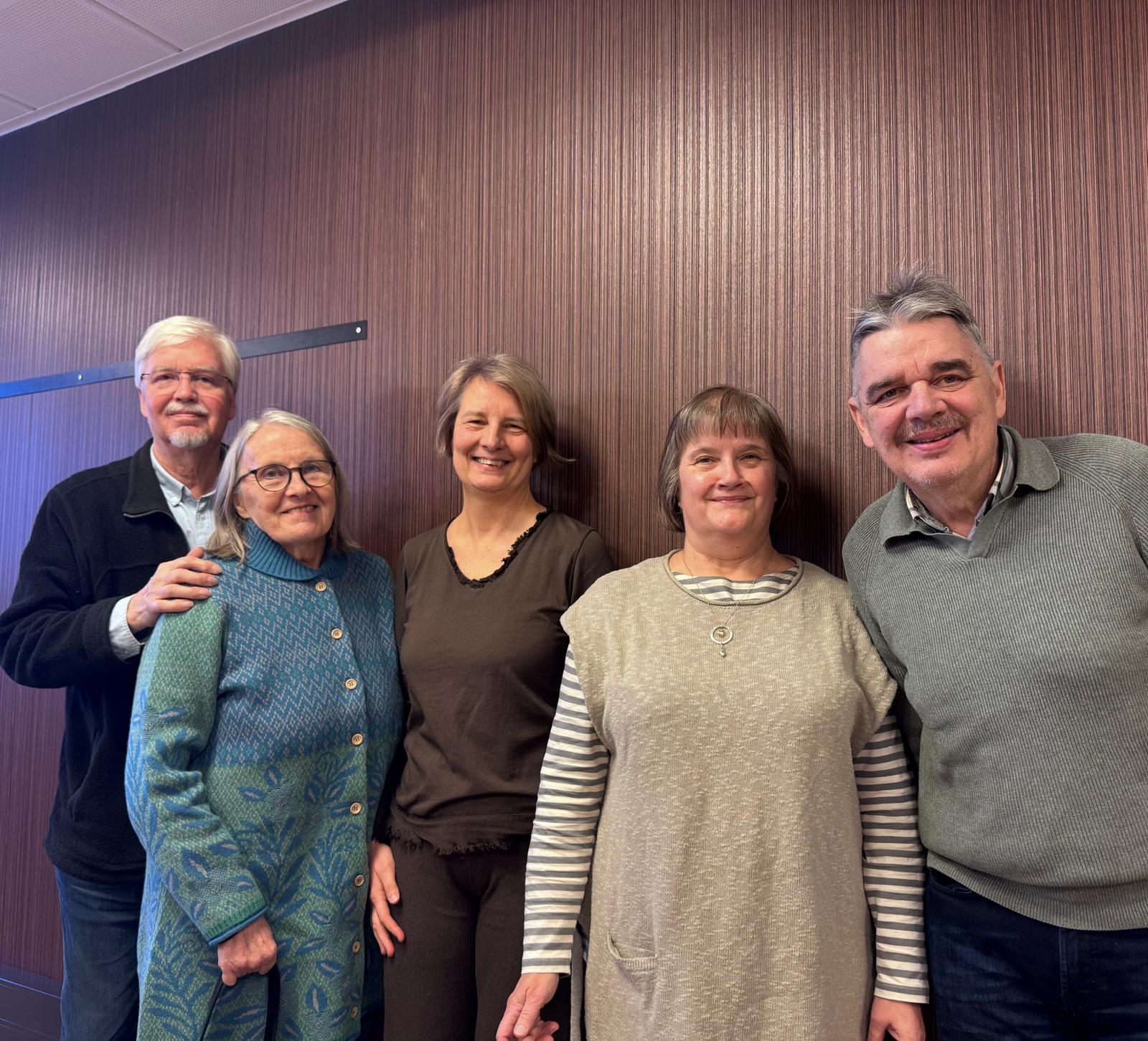 Kuvassa seisoo vierekkäin viisi muistiaktiivia. He kaikki katsovat kameraan ja hymyilevät.