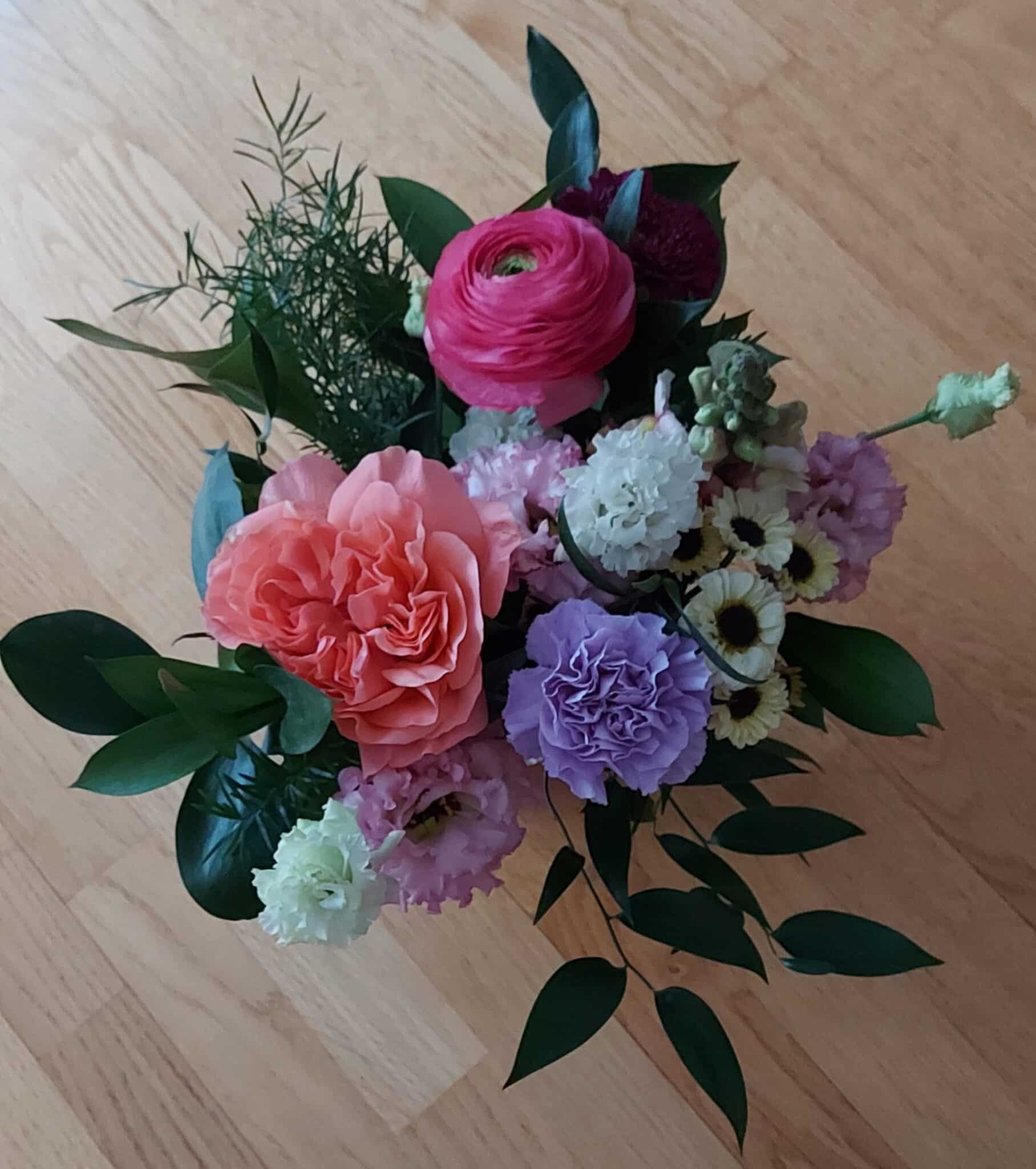 Vantaan Muistiyhdistyksen saama kukkakimppu, jossa on ainakin pinkkejä, violetteja ja valkoisia kukkia.