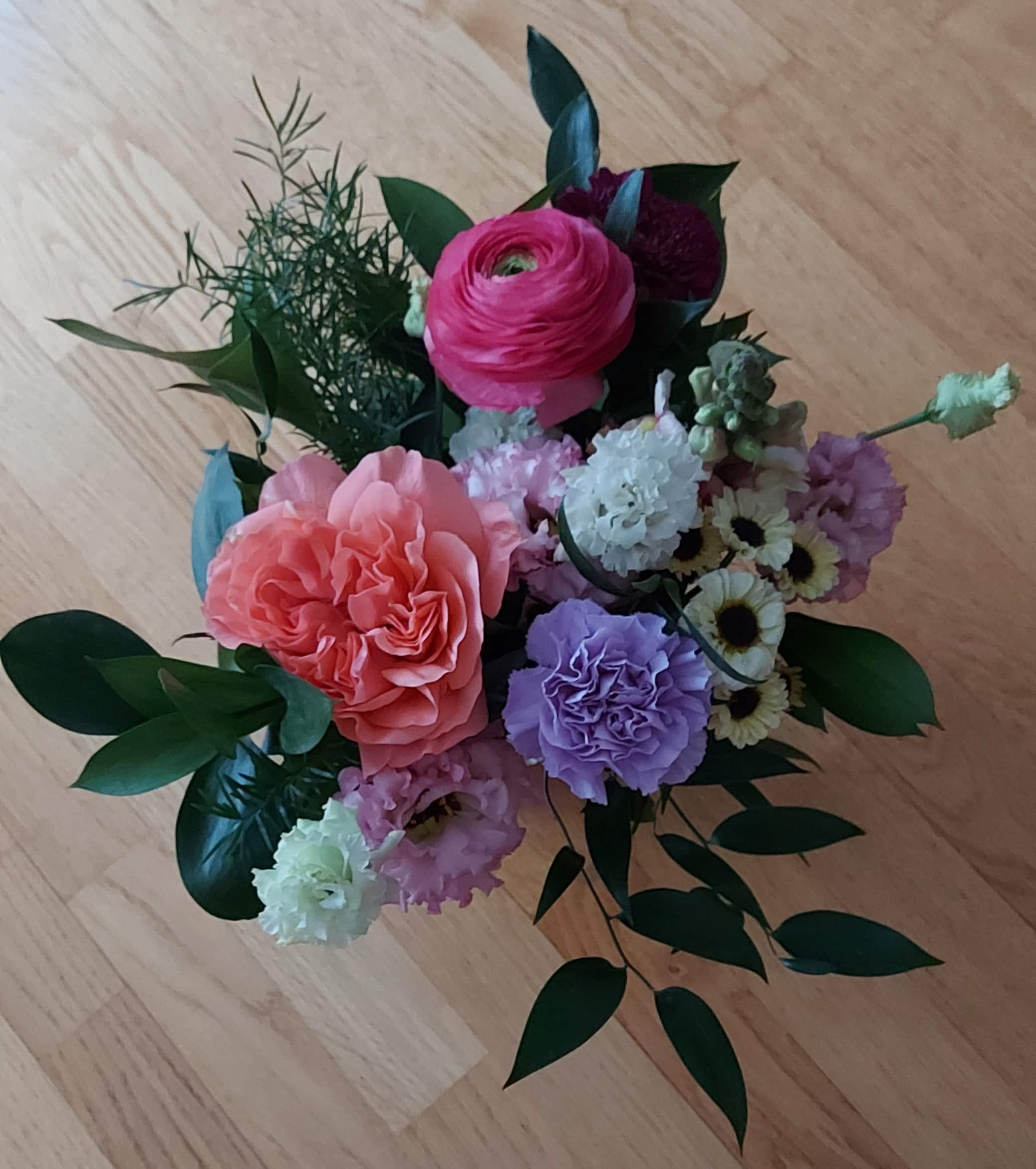 Vantaan Muistiyhdistyksen saama kukkakimppu, jossa on ainakin pinkkejä, violetteja ja valkoisia kukkia.