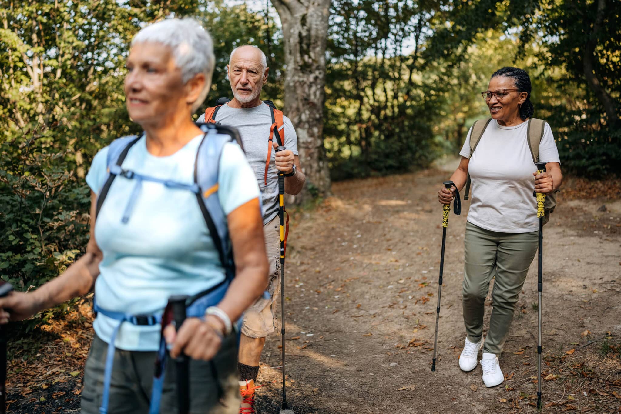 Yhdistysten järjestämä liikuntatoiminta tukee aivoterveyttä ja toimintakykyä. Kuvassa ryhmä sauvakävelijöitä kävelee kesäisessä puistossa.